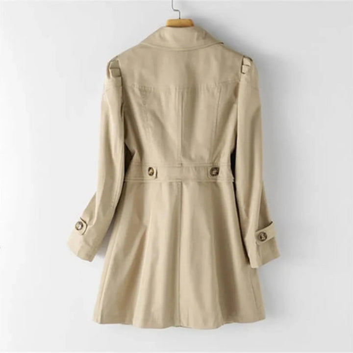Klassisk beige kvinne trenchcoat med doble knapper og belte. Elegant ytterjakke i tidløs stil.