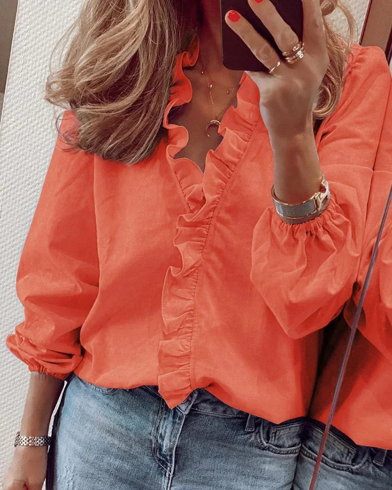 Feminin volangbluse i ensfarget design, perfekt som festtopp eller stilig hverdagsbluse. Moderne stil.