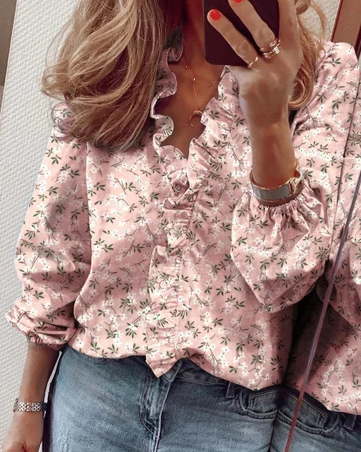 Stilig ensfarget bluse med feminine volanger langs halsen og ballongermer. En moderne vår- og sommerbluse.