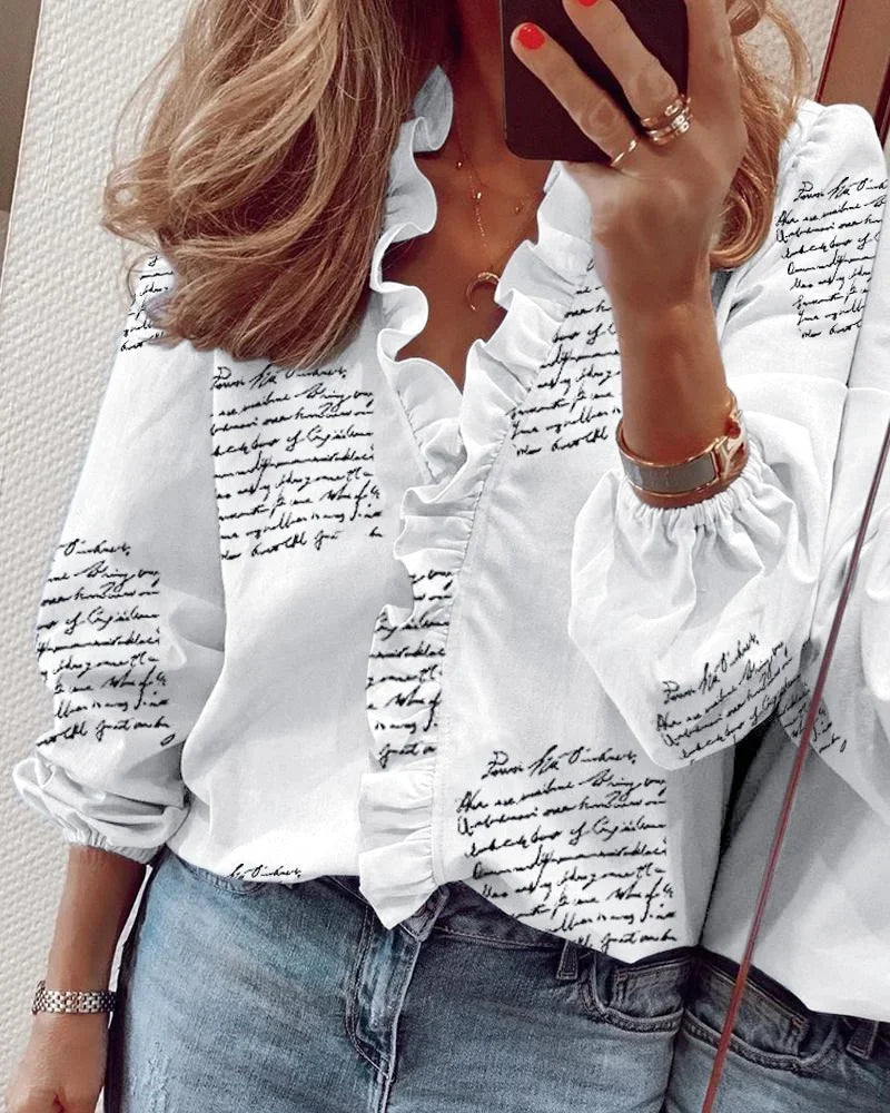 Moderne kvinnebluse med lekne volanger og ballongermer, stylet for et elegant og feminint uttrykk.