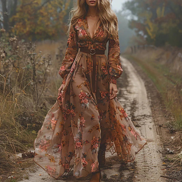 Stilfull kvinnes maxikjole med grønt/mørkebrunt blomstermønster, boho-chic stil, plissert og løs passform.