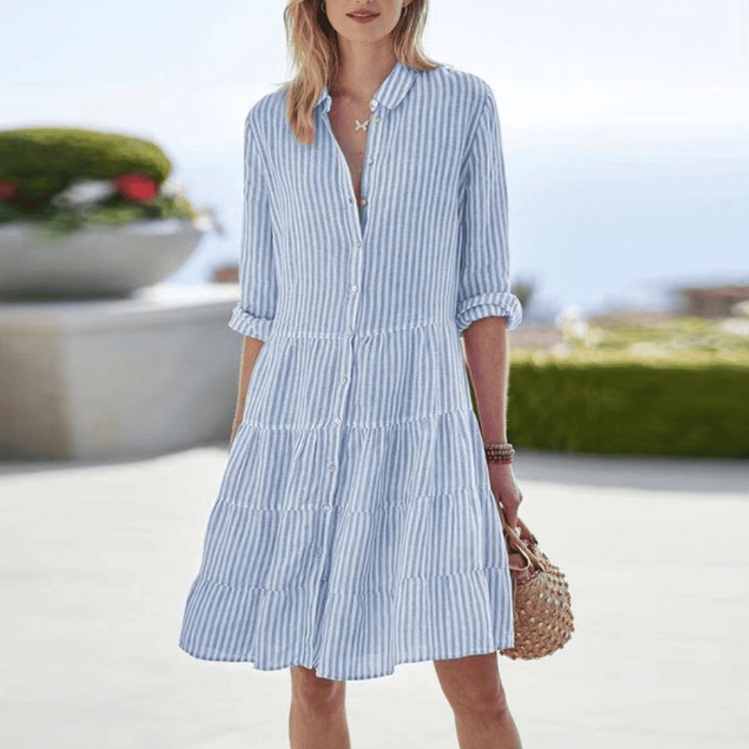 Elegant stripete kvinnekjole med knapper. Komfortabel A-linje kjole, ideell som sommer-, dag- eller strandkjole.
