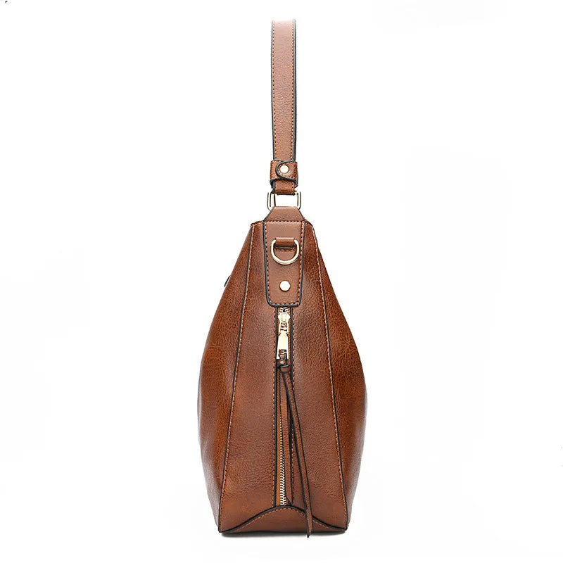 Romslig skinnveske for kvinner. Kan brukes som elegant håndveske, skulderveske eller stilig crossbodyveske.