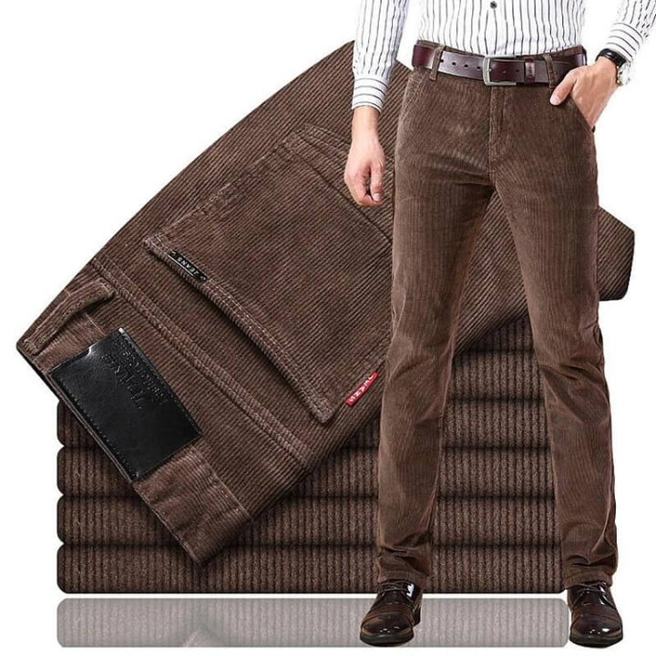 Nærbilde av mørkeblå cordfløyel jeans stoff, viser ribbet tekstur. Klassiske herrejeans, robust og tidløs.