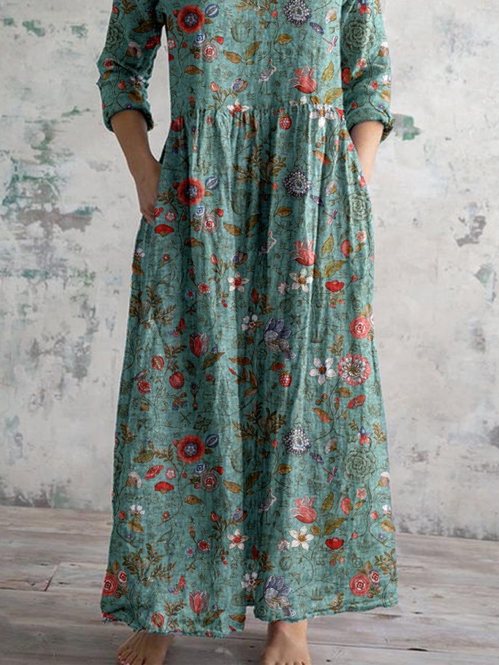 Lett sommerkjole for dame; bohemsk maxikjole med blomsterprint, V-hals og lange ermer. Ideell bomullskjole.