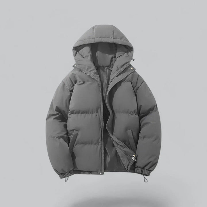 Mann går i snøen med varm, vanntett vinterparka. Ideell herre vinterjakke for tøffe vinterdager og utendørs bruk.