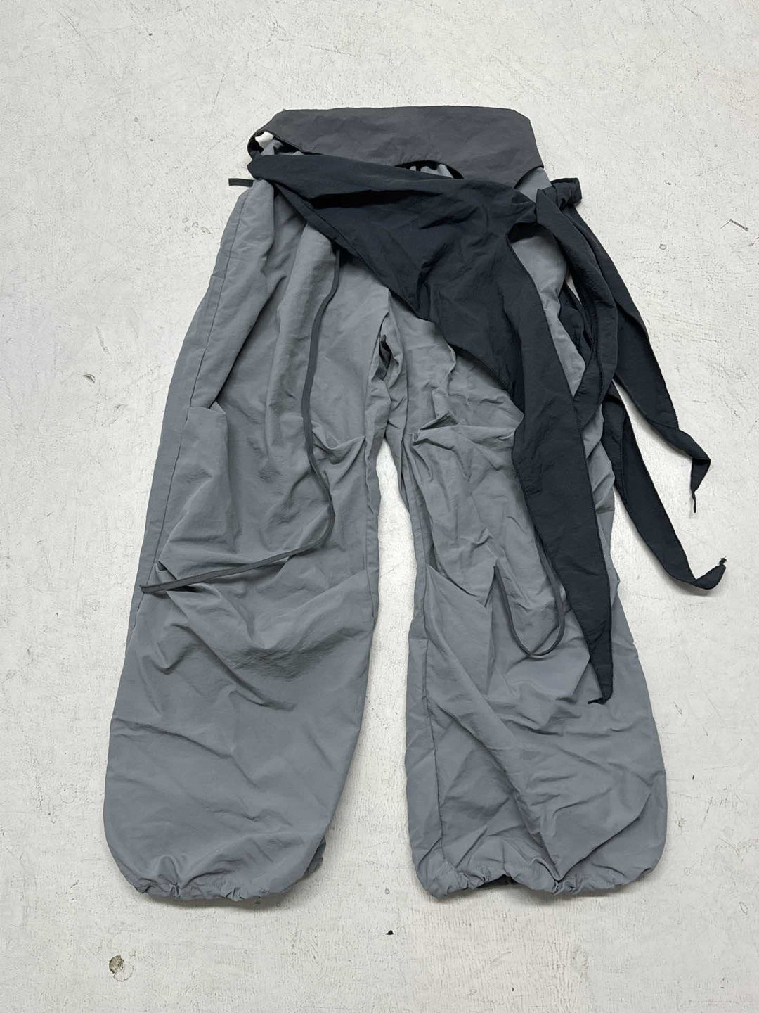 Komfortable vide ben bukser med asymmetrisk design og sidelivsknyting for en chic og avslappet stil.