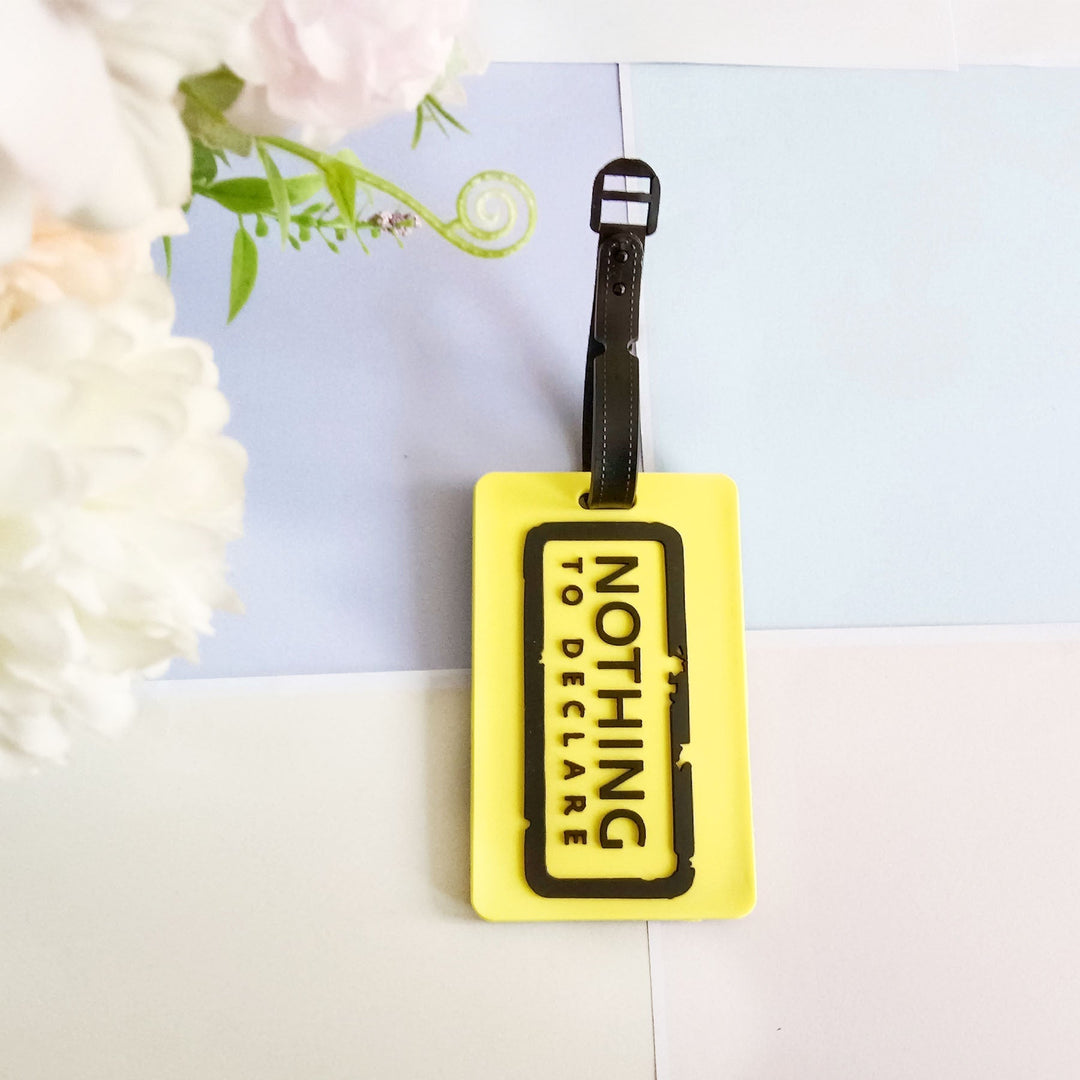 Fleksibel silikon bagasjelapp formet med et universelt flymotiv, for sikker og synlig koffertmerking.