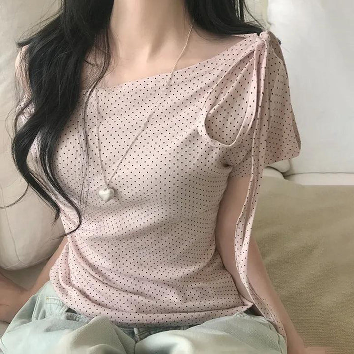 Stilig rosa dametopp med asymmetrisk snitt og elegant dekorativ halslinje for moderne kvinner.