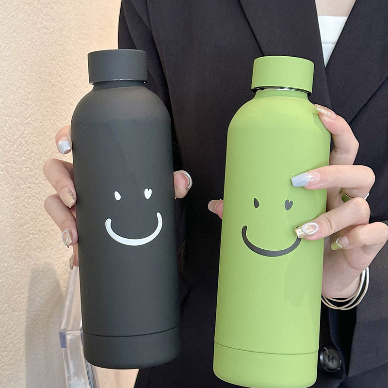 Elegant svart 500ml termoflaske for kvinner. Isolert vannflaske med smilmotiv, ideell for hverdag.