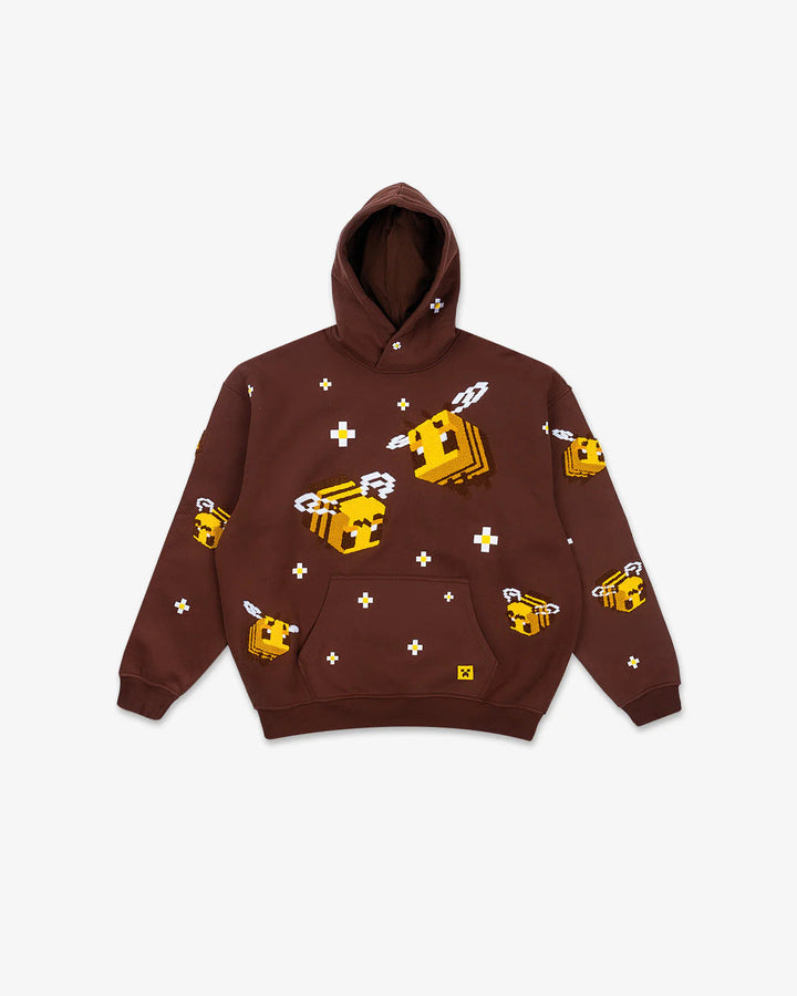 Komfortabel dame hettegenser i lys brun med brodert biemotiv. Unik og trendy for kvinner.
