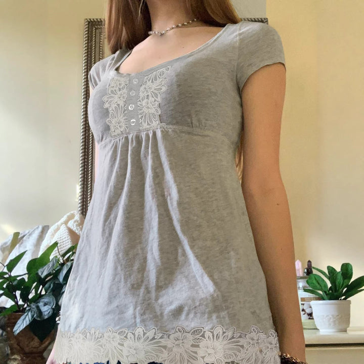 Elegant dame topp med V-hals og knappdetaljer, designet for både casual og formelle antrekk.