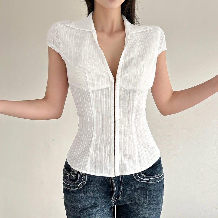 Stilren damebluse med kortermede armer og elegant ståkrage. Glidelåsdetalj for moderne look.