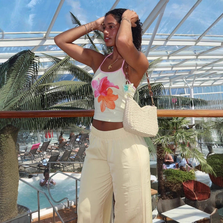 Dame crop-top med unikt blomsterprint og halterneck-design, en fargerik og trendy topp til sommeren.