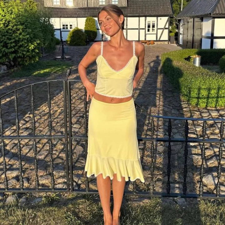 Mote to-delt antrekk: Blonde crop-top og flytende skjørt. Stilrent damesett for uteklær og sommerstil.