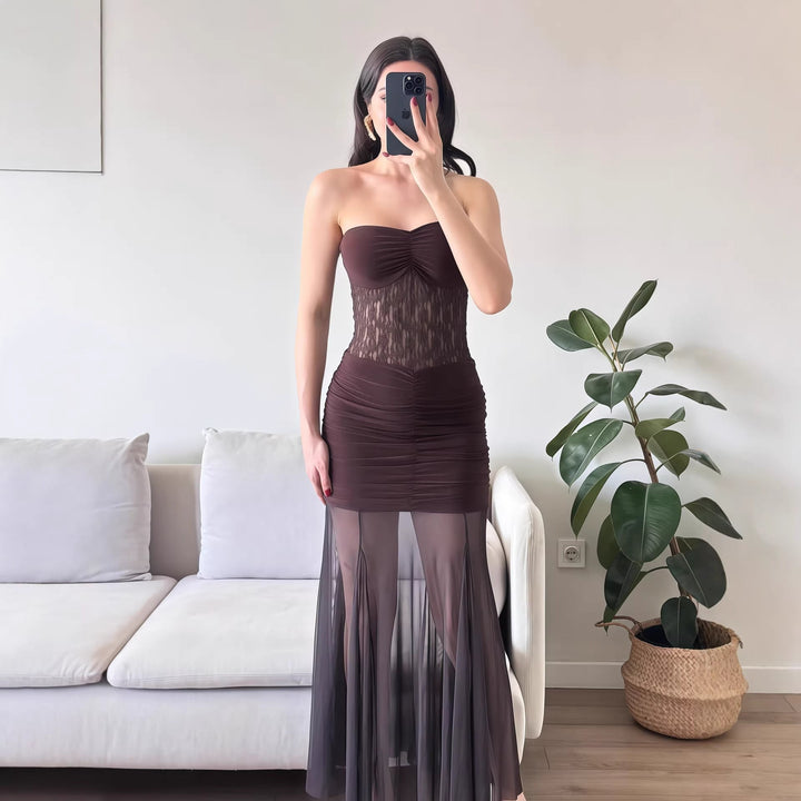 Stilren svart aftenkjole i maxi lengde med elegant snitt, feminine spissdetaljer og flatterende silhuett.
