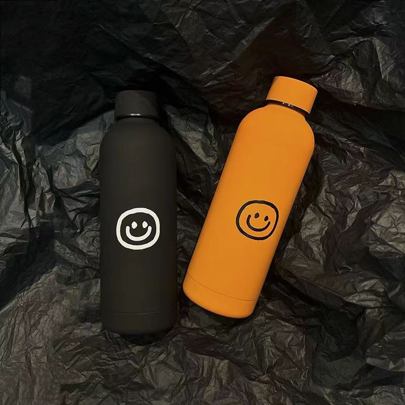 Dobbeltvegget 500ml isolerende stålflaske med smilmotiv, holder drikke varm/kald, ideell for alle.