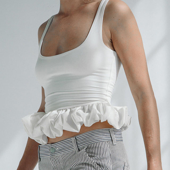 Motebevisst ermeløs dametopp; feminin stil med voluminøs volangkant. Trendy sommermote.