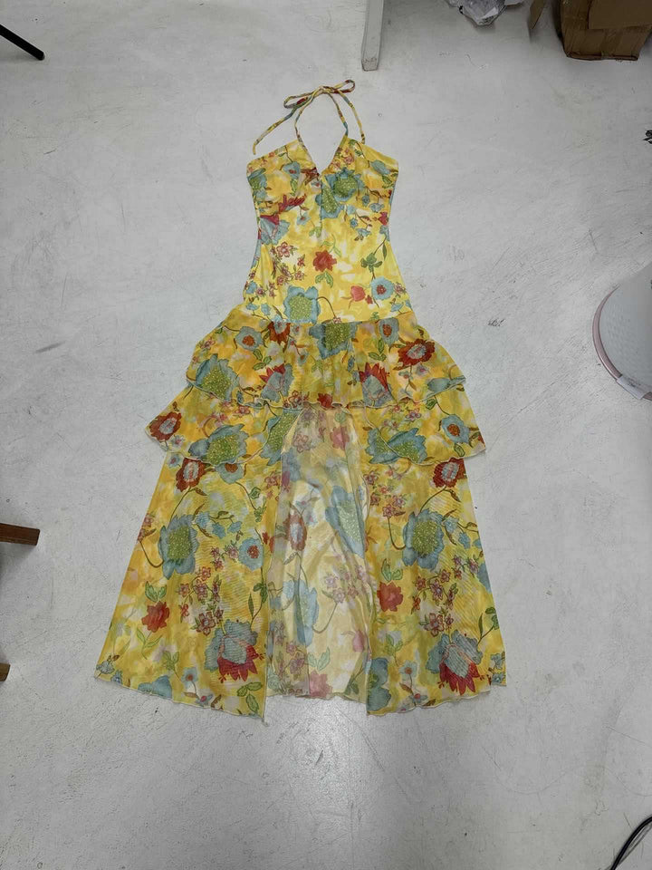 Elegant gul damekjole, maxikjole med tynne spaghetti-stropper og livlig blomstermønster. Flott sommerfestkjole.