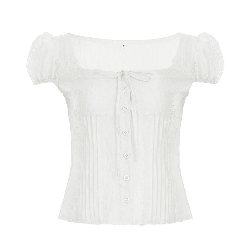 Detaljert bilde av hvit kortermet skjorte med rynker og snøring, viser den feminine og elegante sommerstilen.