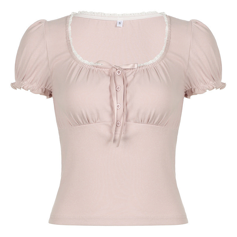 Damebluse i lys rosa med korte ermer, volanger og dekorativt knappedesign, ideell for vår/sommer.