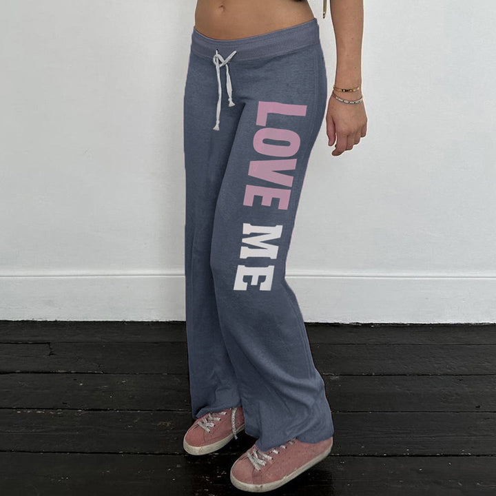 Stilig dame flared joggebukse med unikt mønstertrykk og elegant kontrastbelte. Perfekt casual mote.