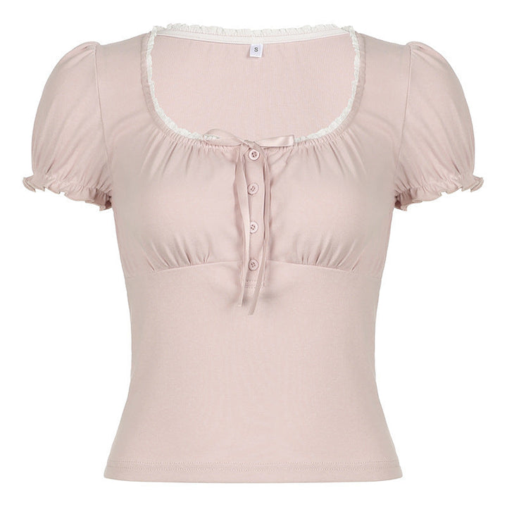 Modell iført trendy kortermet dameskjorte i rosa med volanger og unik knappestolpe, allsidig look.