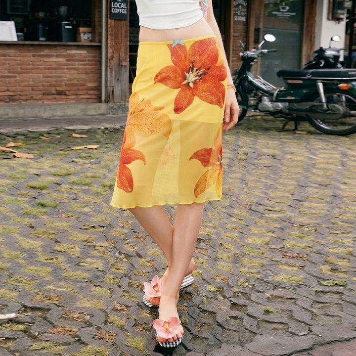 Midi skjørt i gul tone med delikat blomsterprint, A-linje fasong og elastisk midje for optimal komfort.