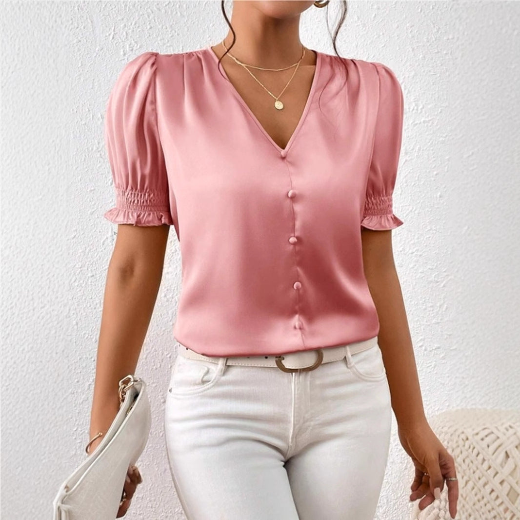 Feminin vårbluse i lett stoff med voluminøse puffermer og gjennomgående knapper. Sommerklar.