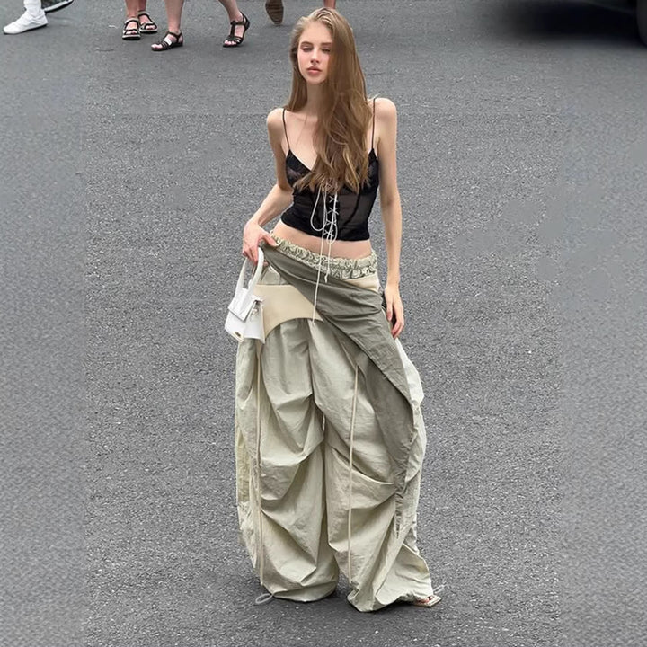 Elegant damebukse med vide ben, høyt liv og trendy sidelivsknyting i asymmetrisk stil.