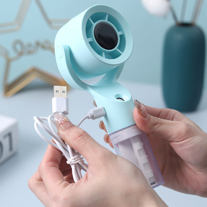 Liten USB-ladbar sprayvifte som gir en kjølig bris med forfriskende fuktighet, ideell for utendørs bruk. (117 tegn)