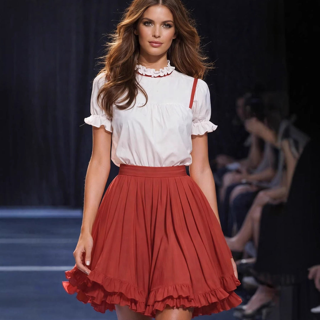Elegant hvit bluse for damer med dekorative knapper og volanger, gir en romantisk vårlook.