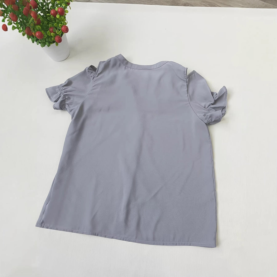 Stilfull grå damebluse med utskårne skuldre, elegant volang og trendy design. Perfekt for fest, kontor eller fritidsbruk.