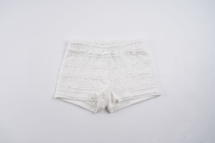 Trendy hvit dame shorts med feminine rysjer og praktisk elastisk midje for en komfortabel hverdag.