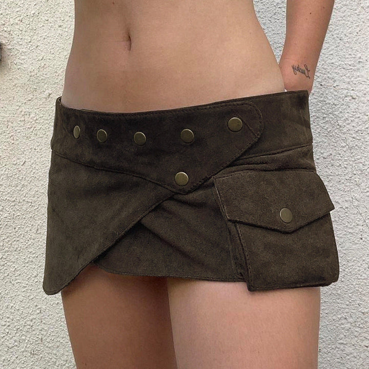 Mørkebrunt trendy miniskjørt for damer med stilige lommer og unike knappdetaljer. Perfekt for vår/sommer.