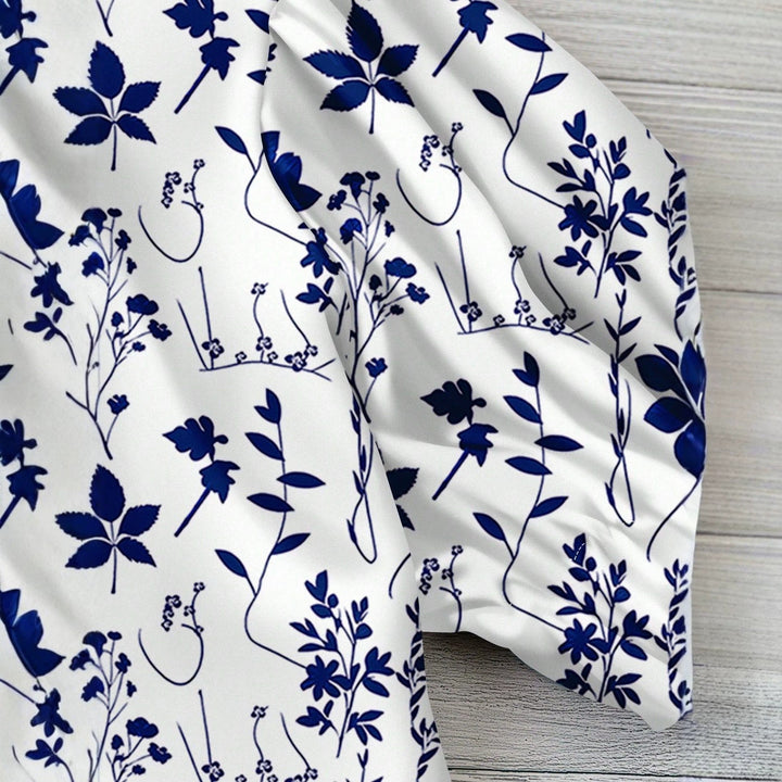 Stilig blå kortermet topp med levende blomsterprint. En trendy sommerbluse og fritidsbluse for kvinner.