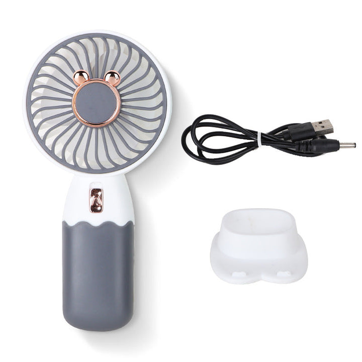 Liten USB-vifte i bruk ved en laptop, perfekt for å holde seg kjølig på kontoret eller hjemmekontoret.