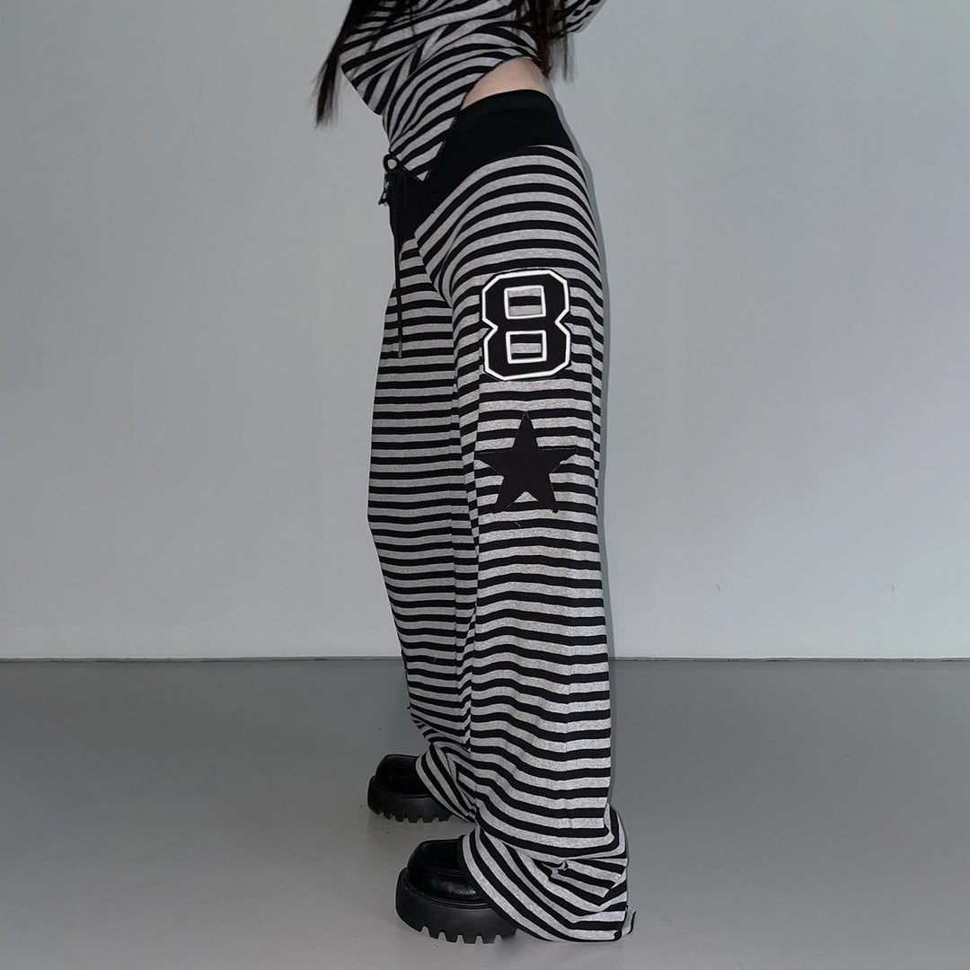 Sporty dame joggebukse med striper, sidelommer og elastisk midje. Perfekt for avslappet stil og trening.