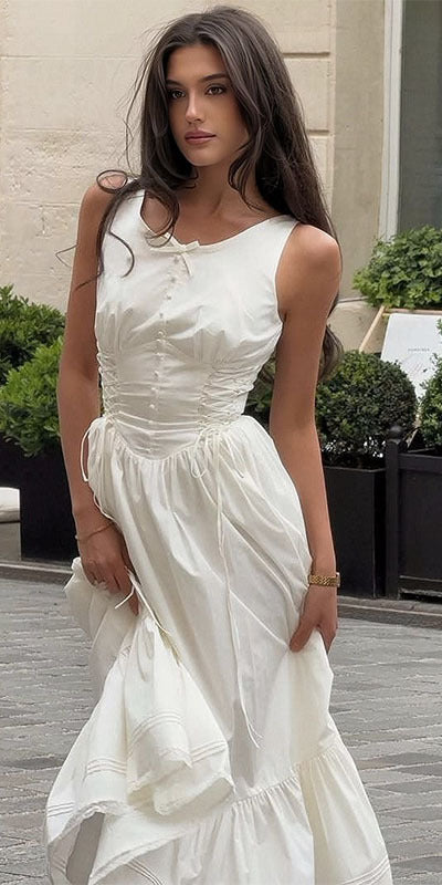 Kvinne i elegant hvit figursydd maxikjole med volanger, perfekt for fest eller sommer. Stilig damekjole.