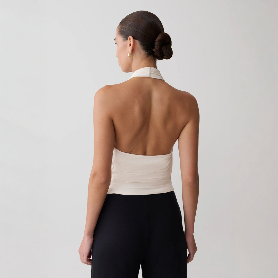 Svart elegant halterneck-topp til dame med dyp utringning. Allsidig festtopp for sommer og kveldsbruk.