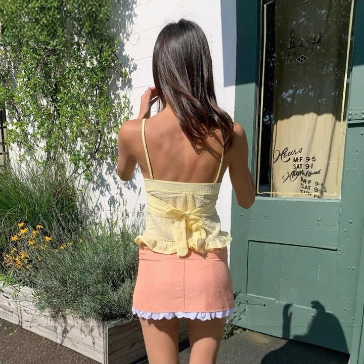 Stilig dame volangtopp med spaghetti-stropper og knapper, ideell som casual sommertopp.
