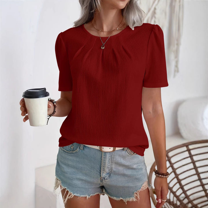 Fasjonabel bluse med teksturert stoff og feminine puffermer, et elegant vårplagg.