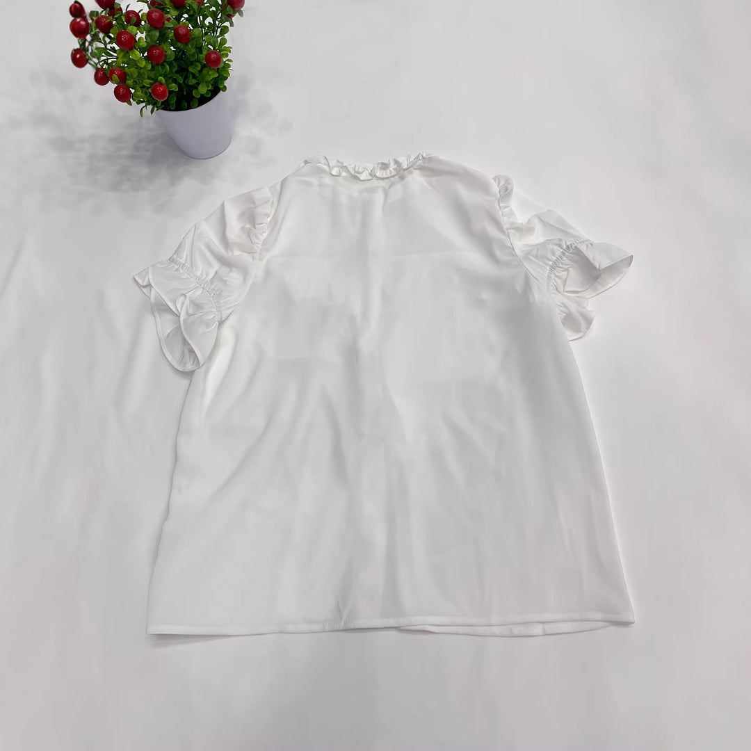 Frisk og elegant hvit damebluse med nydelige volanger. En feminin festtopp som passer perfekt til sommeren.
