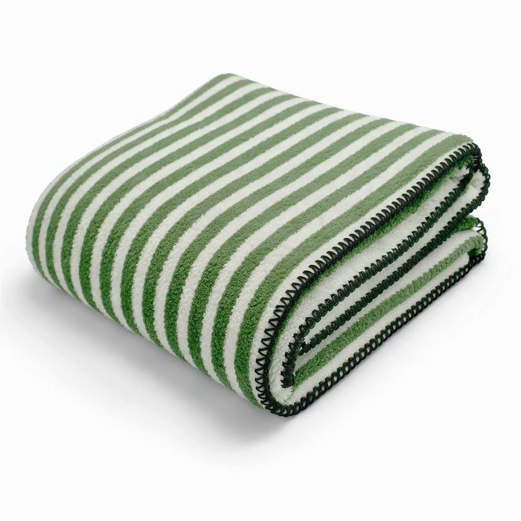 Pent sammenbrettet, mykt fleecepledd med elegant stripedesign. Et varmt og komfortabelt dameteppe for interiør.