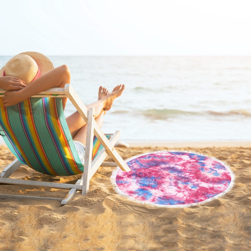 Bærbart rundt strandteppe med elegante frynser. Perfekt strandutstyr for en avslappende sommer.