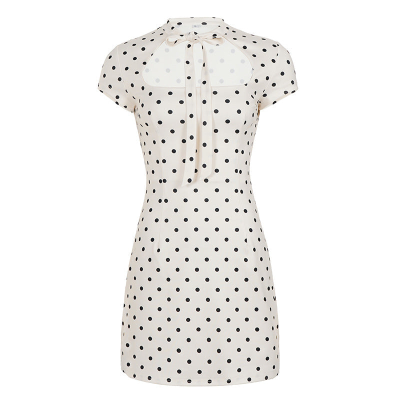 Klassisk hvit og svart polka-dot damekjole. Minilengde, med pen krage og sløyfedetalj for en tidløs stil.
