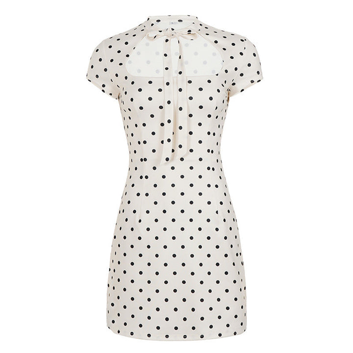 Klassisk hvit og svart polka-dot damekjole. Minilengde, med pen krage og sløyfedetalj for en tidløs stil.
