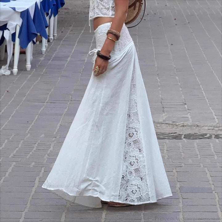 Trendy hvit maxiskjørt for dame med spissdesign og justerbare bånd. Perfekt for sommerlige anledninger.