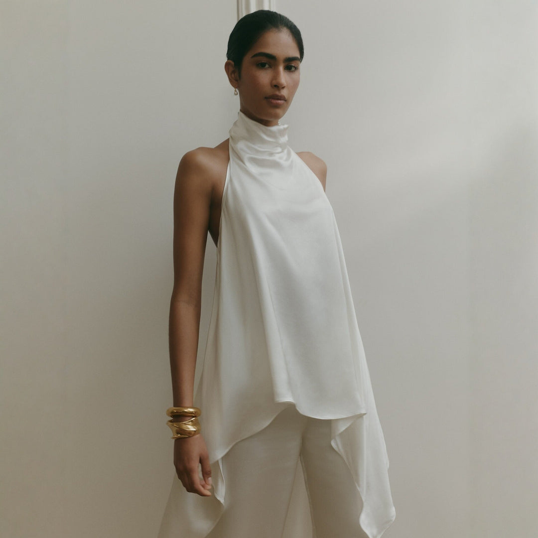 Elegant hvit dame jumpsuit med asymmetrisk snitt og sofistikert krage. Perfekt for fest og kveldsantrekk.
