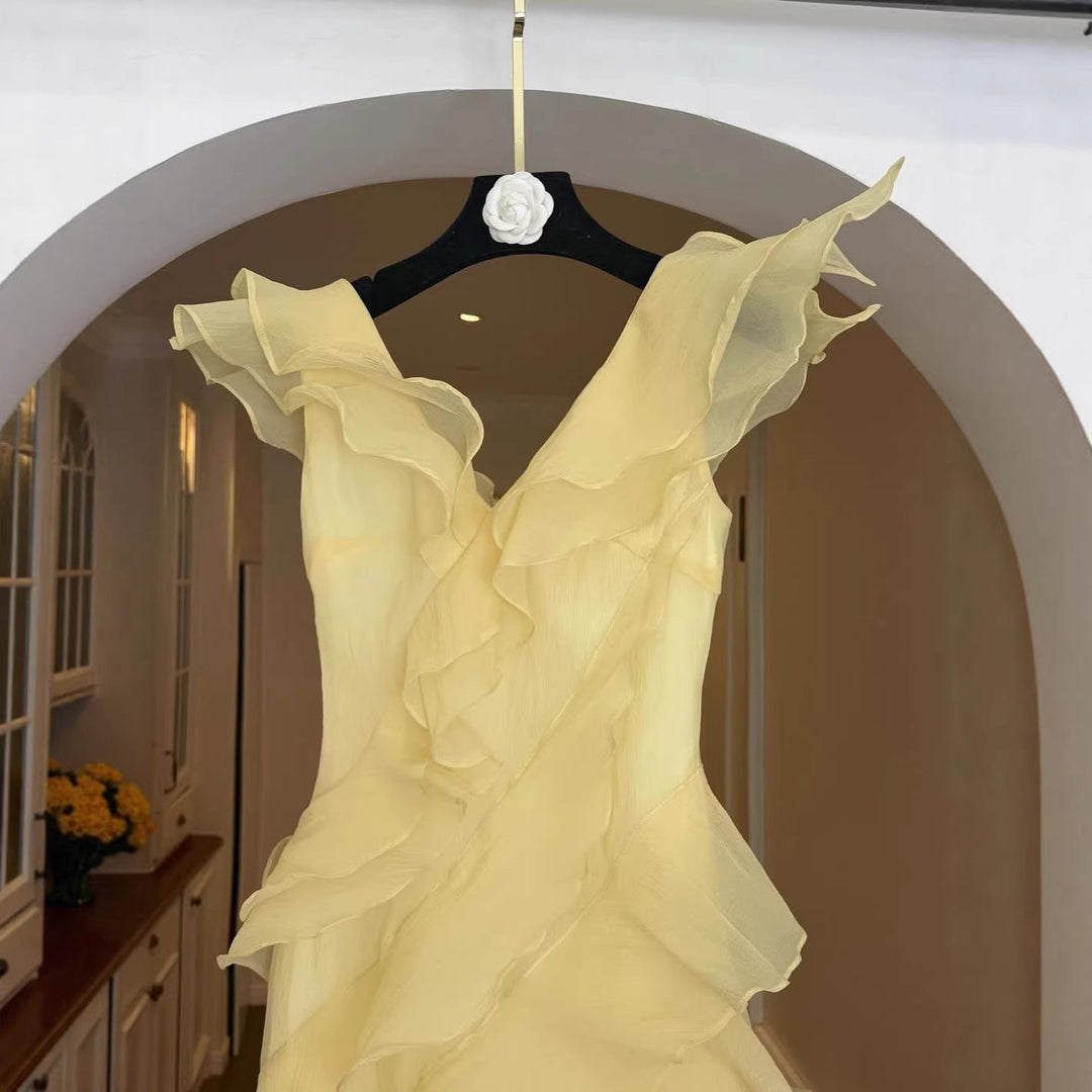 Sofistikert lysegul off-shoulder damekjole med volang. En elegant festkjole eller bryllupsgjestkjole.